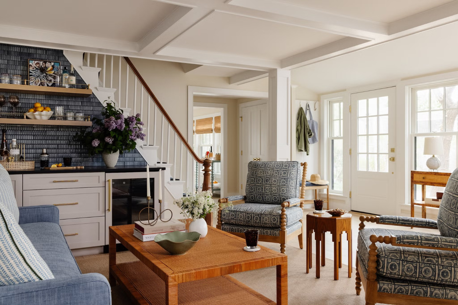 Before AI interior designer living room photo with patterned chairs, blue sofa, dark tile backsplash and warm wood table